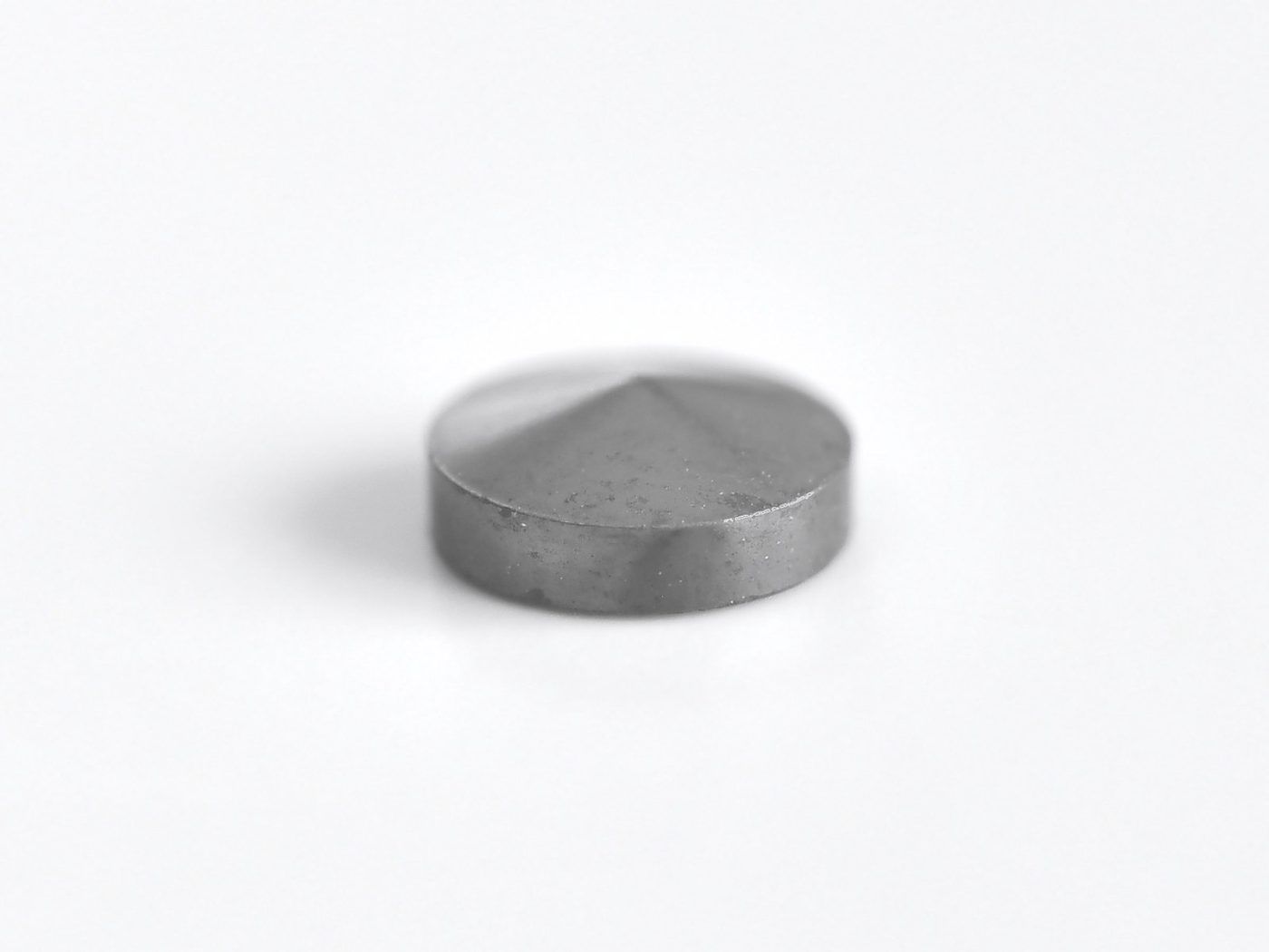 モレクル・コアの単体写真。白い背景に置かれた金属の円盤で、上面の中央から放射状に稜線が出ている